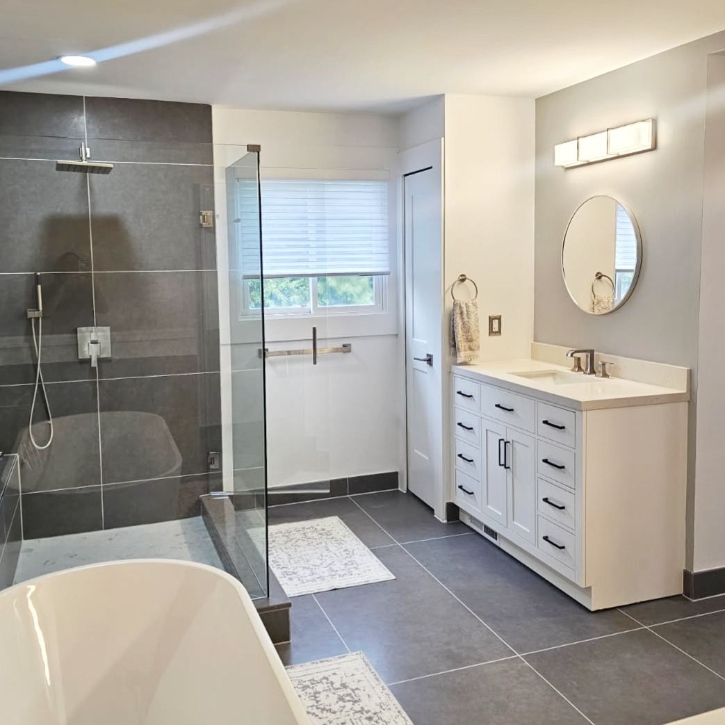 Completed Kaja bathroom with dark tile shower and white vanity